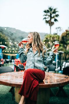 a woman sitting at an outdoor table drinking wine and saying, a lot of fun and drinks this is what friday offers us every weekend