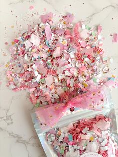 pink and white confetti sprinkles in a bag on a marble surface