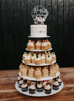 a three tiered cake with cupcakes on it