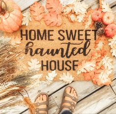 a welcome mat with the words homesweet painted on it next to fall leaves and pumpkins