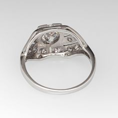 This beautiful circa 1940s engagement ring features a pierced design, accented with milgrain details and is centered with a round transitional brilliant cut diamond, weighing 0.60 carats, in a square bead setting. The top of the ring is accented with sixteen (16) bead set, round single cut diamonds. The ring measures 9.0mm at the top, rises 4.3mm above the finger, tapering to 1.4mm wide and 0.7mm thick at the base of the shank. The ring is currently a size 3 and we offer complimentary resizing to fit. Antique Platinum Round Cut Cluster Ring, Antique Platinum Cluster Ring With Round Cut, Heirloom Diamond Ring With Brilliant Cut, Heirloom Diamond Ring With Brilliant Round Cut, Heirloom Brilliant Cut Round Diamond Ring, Antique Brilliant Cut Round Diamond Ring, Classic Diamond Ring With Single Cut Round Stone, Art Deco Platinum Diamond Ring With Round Cut, Platinum Art Deco Diamond Ring With Round Cut