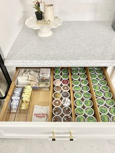 an open drawer in a kitchen filled with lots of cupcakes and other items