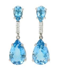 Comprised of pear cut aquamarines prong set as surmounts and drops  Weighing approximately 12.14 and 2.42 carats, respectively Transparent light blue in color and set in opposite directions Separated by a row of prong set round brilliant cut diamonds Weighing approximately 0.24 carat total  G/H color with VS2 clarity Completed by posts with hinged omega backs Tested as 14 karat gold Circa: 2000s  Measures:7/16 x 1 1/2 inches Total Weight: 10..4 grams Stock Number: We-13313 White Gold Drop Earrings, Contemporary Engagement Rings, Heart Drop Earrings, European Cut Diamonds, Diamond Drops, Fancy Color Diamonds, Diamond Drop Earrings, Modern Earrings, Gold Drop Earrings