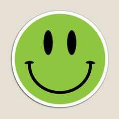 a green smiley face sticker with two black eyes and one white smile on it