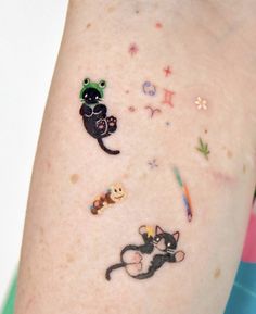 a person with tattoos on their arm and one has an animal sticker on it