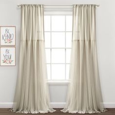 a white curtain hanging in front of a window with two pictures on the wall behind it