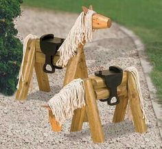 two wooden horse sculptures sitting on top of a sidewalk