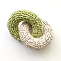 a green and white crocheted brooch sitting on top of a white table