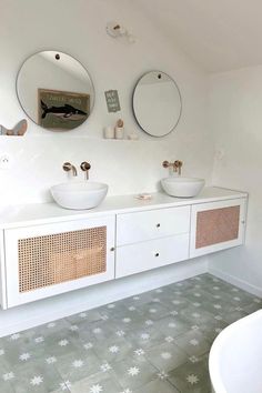 a bathroom with two sinks and mirrors on the wall next to a bathtub in it