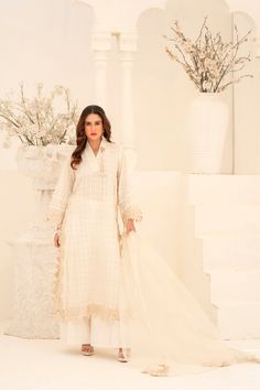 Expertly crafted from khaadi organza, this White Wide Leg Shalwar Kameez features delicate cutwork lace all over the body and the chaak of the shirt. Paired with an organza dupatta featuring cutwork flowers, and khaadi silk palazzo pants for a sophisticated and stylish look. Semi-stitched Traditional Wear With Lace Work For Eid, Formal Organza Kurta With Naqshi Detailing, Formal Naqshi Organza Kurta, Elegant Sharara With Naqshi For Eid, Elegant Naqshi Sharara For Eid, Designer White Salwar Kameez With Naqshi Detailing, Designer White Salwar Kameez With Naqshi, Designer White Naqshi Salwar Kameez, Organza Sharara With Naqshi For Diwali