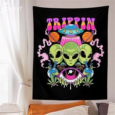 a tapestry hanging on the wall in a bedroom with an alien themed poster above it