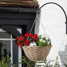 a hanging basket filled with flowers next to a window