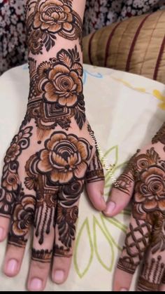 a woman's hands with hennap and flowers on it