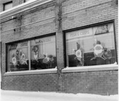 an old black and white photo of fish and chips in the window sill of a brick building