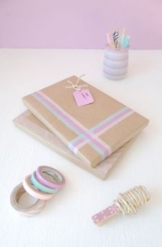 a table topped with lots of wrapping paper next to tape and washi dispensers