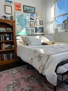 a bed sitting in a bedroom next to a book shelf filled with lots of books