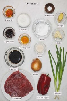 an assortment of ingredients are displayed on a white counter top, including onions, peppers, garlic, and meat