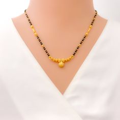 This 22k gold mangal sutra, weighing 9.6 grams, features a beautifully textured design that enhances its radiant yellow gold finish. The black bead detailing adds a traditional touch, while the 16-inch necklace length provides a comfortable and elegant fit. The 0.25-inch drop length creates a subtle yet refined accent, and the hook lock ensures security and ease of wear. Combining cultural heritage with a modern aesthetic, this piece is ideal for those seeking a timeless yet stylish symbol of marital unity. PRODUCT DETAILS Gold Purity(karat): 22k Item Weight(grams): 9.6 Item Finish: Yellow Gold Stone: Black Bead Necklace Length: 16" Drop Length: 0.25" Lock Style: Hook Lock Gold Jewelry With Black Beads For Puja, Gold Necklace With Black Beads For Puja, Elegant Yellow Necklace For Puja, Traditional Gold Necklace With Black Beads, Traditional Yellow Gold Jewelry With Black Beads, Festive Black Necklace With Gold Beads, Elegant Black Temple Necklace As Gift, Elegant Black Temple Necklace Gift, Gold Temple Jewelry With Black Beads