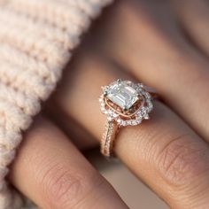 a close up of a person's hand with a diamond ring on their finger