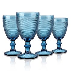 four blue glass goblets sitting next to each other