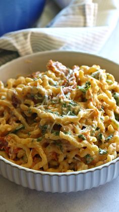 a white bowl filled with pasta covered in sauce