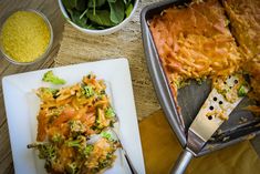 a casserole dish with broccoli and cheese next to a serving knife