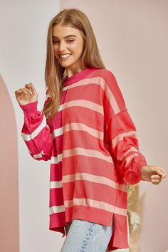 This sweater plays by its own rules. While other tops cling to conventions, the Not Playing Games striped sweater throws the style rule book out the window with its hi-lo hemline and oversized silhouette. Knit from the coziest coral and magenta yarns, it’s a bold fusion of comfort and nonconformity. The round neckline and soft, lightweight knit ensure you feel as fabulous as you look, whether you’re pairing it with distressed denim for a casual statement or a pleated mini for some rebellious pol Rachel Clark, Style Rules, Oversized Silhouette, Striped Sweater, Playing Games, Knitting Materials, The Window, Stripe Sweater, Distressed Denim