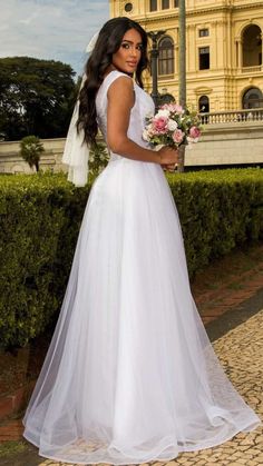 a woman in a wedding dress standing outside