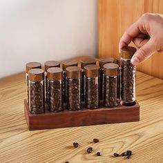 a person is picking up some coffee beans from a wooden container on a table with other items