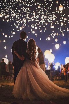 a man and woman standing under lanterns in the sky with words written below them that read,