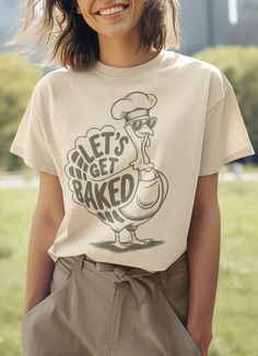 A funny thanksgiving shirt with a cartoon turkey that says 'let's get baked'. This shirt is perfect for those who enjoy humor and want to add a bit of fun to their Thanksgiving celebrations. It is relevant to those who love quirky holiday-themed apparel and are looking to stand out at gatherings. This classic unisex jersey short sleeve tee fits like a well-loved favorite. Soft cotton and quality print make users fall in love with it over and over again. These t-shirts have-ribbed knit collars to bolster shaping. The shoulders are tapered for a better fit over time. Dual side seams hold the garment's shape for longer. .: Made with 100% Airlume combed and ring-spun cotton, a lightweight fabric (4.2 oz/yd² (142 g/m that is easy to layer, breathable. Perfect for active and leisure wear.  .: Th Cartoon Turkey, Cartoon Bird, Friendsgiving Party, Funny Thanksgiving Shirts, Holiday Feast, Holiday Meal, Thanksgiving Shirt, Funny Thanksgiving, Retro Cartoons