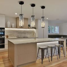 a modern kitchen with an island and bar stools