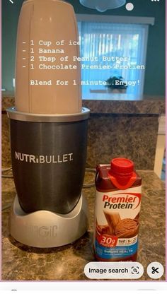 a blender sitting on top of a counter next to a bottle of nut butter