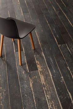 a black chair sitting on top of a wooden floor