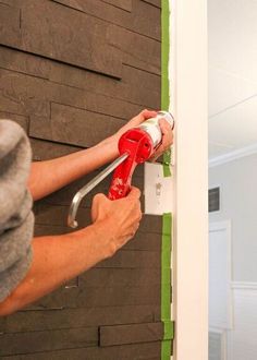 a person using a paint roller to fix a wall