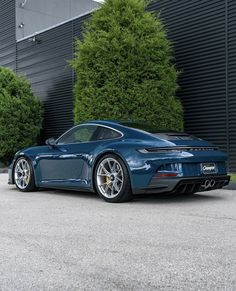 a blue sports car parked in front of a building