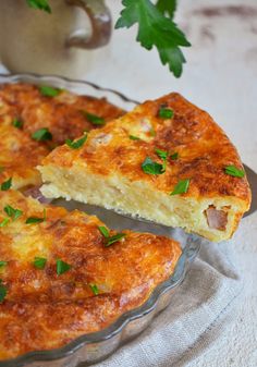 a cheesy casserole on a glass plate with a piece cut out