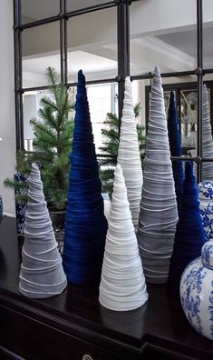 blue and white vases are lined up on a dresser in front of a mirror