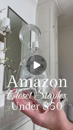 someone is holding an empty glass bottle in front of a mirror with the words amazon clear staples under $ 50