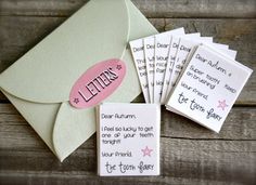 a bunch of cards that are sitting on top of a wooden table next to an envelope