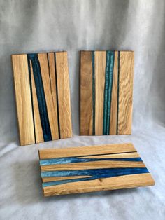 three pieces of wood sitting on top of a white table next to blue and green strips