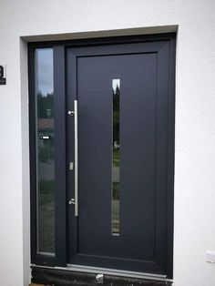 a black front door with two sidelights and glass panels on the top half of it