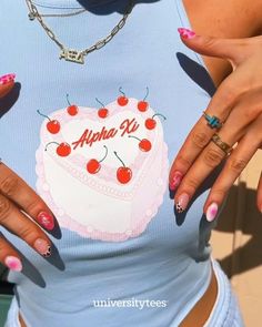 a woman with her hands on her hips holding a heart shaped cake in front of her chest