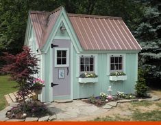 a small green house with pink door and windows