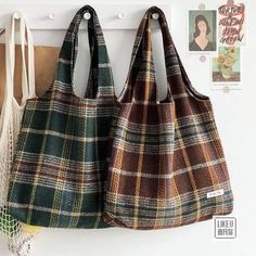 two purses hanging on the wall next to each other in front of pictures and magnets