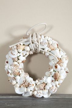 a wreath made out of seashells sitting on top of a shelf next to a wall