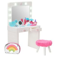 a white vanity table with a pink stool and mirror on top of it next to a rainbow shaped foot stool