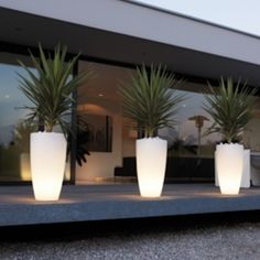 two large white planters sitting on top of a window sill next to a building