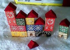 a group of small wooden houses sitting on top of a white blanket next to a box