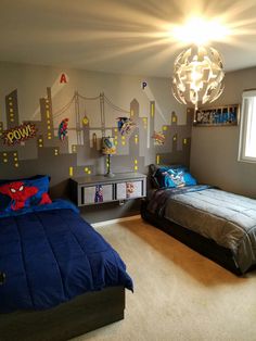 two twin beds in a bedroom decorated with spiderman decals and wall stickers